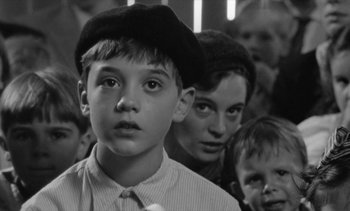 Movie still from “Jacquot of Nantes” (1991), directed by Agnès Varda – A black and white photo of a group of children; Close Up shot, Over the shoulder angle