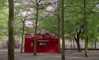 Movie still from “Jacquot of Nantes” (1991), directed by Agnès Varda – A red building in the middle of a park; Extreme Wide shot, High angle