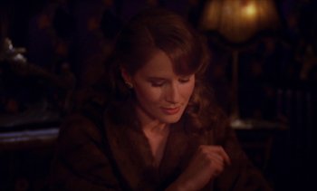 Movie still from “Jacquot of Nantes” (1991), directed by Agnès Varda – A beautiful woman sitting down in a dark room; Close Up shot, Over the shoulder angle