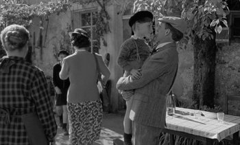 Movie still from “Jacquot of Nantes” (1991), directed by Agnès Varda – An old photo of a man and a boy; Medium shot, Over the shoulder angle