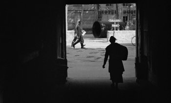 Movie still from “Jacquot of Nantes” (1991), directed by Agnès Varda – A man and a woman walking down a street; Wide shot, Over the shoulder angle