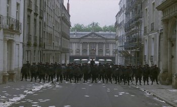 Movie still from “Jacquot of Nantes” (1991), directed by Agnès Varda – A large group of people are marching down the street; Extreme Wide shot, High angle