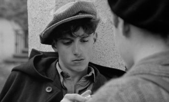 Movie still from “Jacquot of Nantes” (1991), directed by Agnès Varda – A young man wearing a hat looking at a young woman; Close Up shot, Over the shoulder angle