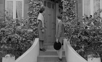 Movie still from “Jacquot of Nantes” (1991), directed by Agnès Varda – Two women are standing on the steps of a house; Wide shot, Low angle
