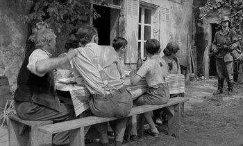 Movie still from “Jacquot of Nantes” (1991), directed by Agnès Varda – A black and white photo of people sitting at a table; Wide shot, Over the shoulder angle