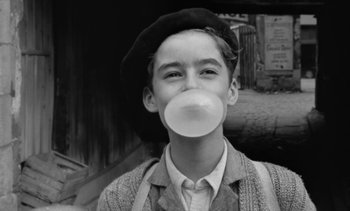 Movie still from “Jacquot of Nantes” (1991), directed by Agnès Varda – A young man with a bubble gum chewing gum; Close Up shot, Low angle