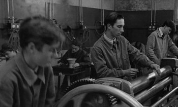 Movie still from “Jacquot of Nantes” (1991), directed by Agnès Varda – A black - and - white photo of men working in a factory; Medium shot, High angle
