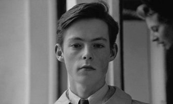 Movie still from “Jacquot of Nantes” (1991), directed by Agnès Varda – Black and white photograph of a young man wearing a shirt and tie; Close Up shot, High angle