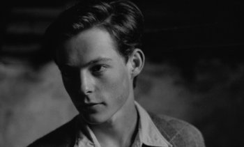 Movie still from “Jacquot of Nantes” (1991), directed by Agnès Varda – Black and white photograph of a young man; Close Up shot, Low angle