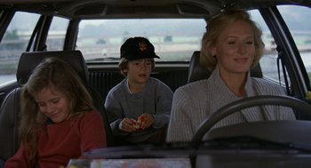 Movie still from “Jagged Edge” (1985), directed by Richard Marquand – A boy sitting in the back seat of a car with two women; Medium shot, Over the shoulder angle