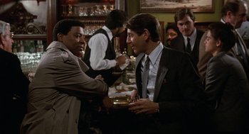 Movie still from “Jagged Edge” (1985), directed by Richard Marquand – Two men shaking hands in a restaurant; Medium shot, Over the shoulder angle