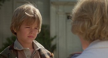 Movie still from “Jagged Edge” (1985), directed by Richard Marquand – A young boy and an older woman are talking outside; Close Up shot, Over the shoulder angle
