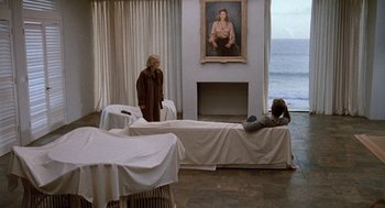 Movie still from “Jagged Edge” (1985), directed by Richard Marquand – Two people in a room with a painting on the wall; Wide shot, High angle