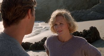 Movie still from “Jagged Edge” (1985), directed by Richard Marquand – A woman standing next to a man on a beach; Close Up shot, Over the shoulder angle