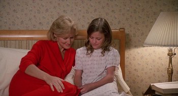 Movie still from “Jagged Edge” (1985), directed by Richard Marquand – A woman sitting next to a young girl on a bed; Medium shot, High angle