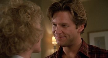 Movie still from “Jagged Edge” (1985), directed by Richard Marquand – A man smiles at a woman with blonde curly hair; Close Up shot, Over the shoulder angle