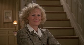 Movie still from “Jagged Edge” (1985), directed by Richard Marquand – A woman sitting in front of a stair case; Medium shot, Low angle