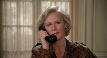 Movie still from “Jagged Edge” (1985), directed by Richard Marquand – An older woman talking on a phone in a room; Close Up shot, High angle