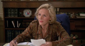 Movie still from “Jagged Edge” (1985), directed by Richard Marquand – A woman sitting at a table holding a piece of paper; Close Up shot, Over the shoulder angle