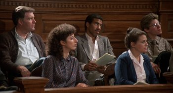 Movie still from “Jagged Edge” (1985), directed by Richard Marquand – A man and a woman sitting in front of a judge; Medium shot, High angle