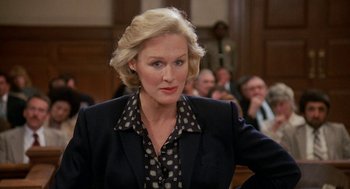 Movie still from “Jagged Edge” (1985), directed by Richard Marquand – A woman in a suit in a court room; Close Up shot, Low angle