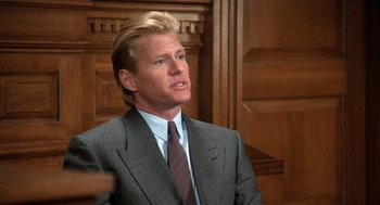 Movie still from “Jagged Edge” (1985), directed by Richard Marquand – A man wearing a suit and tie in a room; Close Up shot, Low angle