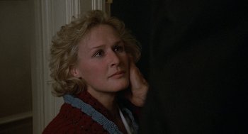 Movie still from “Jagged Edge” (1985), directed by Richard Marquand – A woman with blonde curly hair wearing a red sweater; Close Up shot, Over the shoulder angle