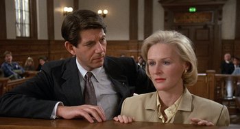 Movie still from “Jagged Edge” (1985), directed by Richard Marquand – A man and a woman sitting at a table in a courtroom; Close Up shot, Over the shoulder angle