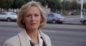 Movie still from “Jagged Edge” (1985), directed by Richard Marquand – A person outside near a street; Close Up shot, Over the shoulder angle