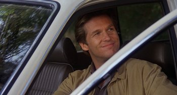 Movie still from “Jagged Edge” (1985), directed by Richard Marquand – A man sitting in the driver's seat of a car; Close Up shot, Over the shoulder angle