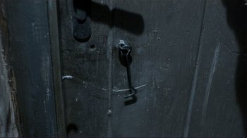 Movie still from “Jakob the Liar” (1999), directed by Peter Kassovitz – A black door with a black handle on it's side; Extreme Close Up shot, High angle
