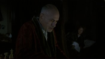 Movie still from “Jakob the Liar” (1999), directed by Peter Kassovitz – An older man wearing a red robe and a black robe; Medium shot, Over the shoulder angle