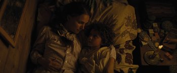 Movie still from “Jane Got a Gun” (2015), directed by Gavin O'Connor – A woman and a child laying in a bed together; Close Up shot, Overhead angle