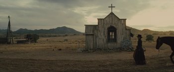 Movie still from “Jane Got a Gun” (2015), directed by Gavin O'Connor – An old wooden church with a cross on the top of it; Extreme Wide shot, Low angle