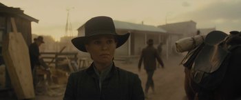 Movie still from “Jane Got a Gun” (2015), directed by Gavin O'Connor – A woman wearing a cowboy hat in the middle of the desert; Medium shot, Low angle