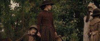 Movie still from “Jane Got a Gun” (2015), directed by Gavin O'Connor – A woman and a little girl holding hands; Medium shot, Over the shoulder angle