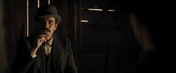 Movie still from “Jane Got a Gun” (2015), directed by Gavin O'Connor – A man wearing a hat and a jacket; Close Up shot, Low angle