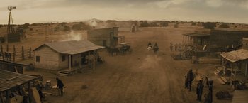 Movie still from “Jane Got a Gun” (2015), directed by Gavin O'Connor – Two men on horses are riding in a dirt field; Extreme Wide shot, High angle