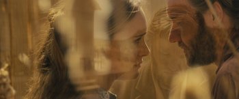 Movie still from “Jane Got a Gun” (2015), directed by Gavin O'Connor – A woman looking out of a window at a person; Close Up shot, Over the shoulder angle