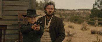 Movie still from “Jane Got a Gun” (2015), directed by Gavin O'Connor – A man and a woman holding a gun in a field; Medium shot, Over the shoulder angle