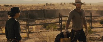 Movie still from “Jane Got a Gun” (2015), directed by Gavin O'Connor – A man standing in the middle of an open field; Medium shot, Over the shoulder angle