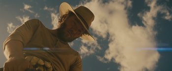 Movie still from “Jane Got a Gun” (2015), directed by Gavin O'Connor – A man with a cowboy hat on looking at the camera; Close Up shot, Low angle