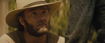 Movie still from “Jane Got a Gun” (2015), directed by Gavin O'Connor – A person wearing a hat; Close Up shot, Over the shoulder angle