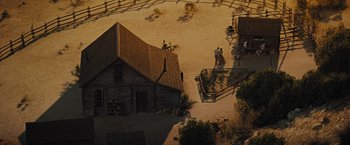 Movie still from “Jane Got a Gun” (2015), directed by Gavin O'Connor – A group of people standing on top of a dirt field; Extreme Wide shot, High angle