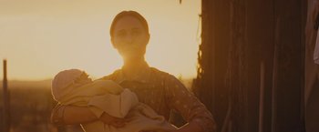 Movie still from “Jane Got a Gun” (2015), directed by Gavin O'Connor – A woman is holding a baby in her arms; Close Up shot, Low angle