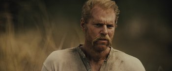 Movie still from “Jane Got a Gun” (2015), directed by Gavin O'Connor – A person with a beard and mustache; Close Up shot, Over the shoulder angle