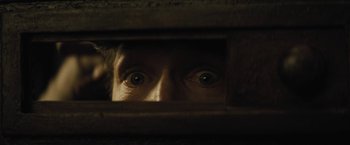 Movie still from “Jane Got a Gun” (2015), directed by Gavin O'Connor – A man looking through a hole in the wall; Extreme Close Up shot, Overhead angle