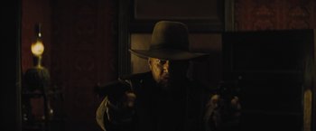 Movie still from “Jane Got a Gun” (2015), directed by Gavin O'Connor – A man with a hat and a gun in his hand; Medium shot, Low angle