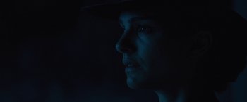 Movie still from “Jane Got a Gun” (2015), directed by Gavin O'Connor – A man with a hat is looking into the dark; Close Up shot, Low angle