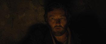 Movie still from “Jane Got a Gun” (2015), directed by Gavin O'Connor – A person with a beard in the dark; Close Up shot, Low angle
